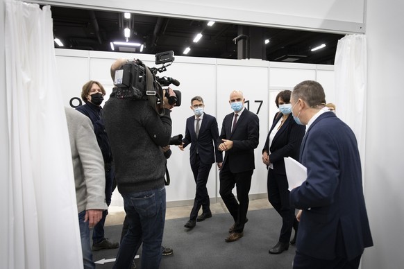 Bundesrat Alain Berset, Mitte, Regierungsrat Lukas Engelberger, links, und Regierungspraesidentin Elisabeth Ackermann, rechts, waehrend einem Besuch im Impfzentrum Basel Stadt, am Montag, 28. Dezember ...