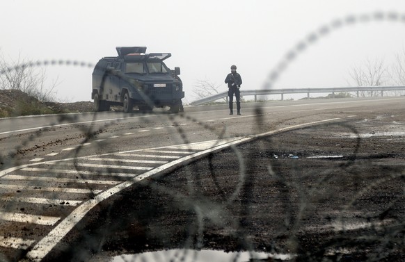 Kosovo police officers guard checkpoint on the road near the northern Kosovo border crossing of Jarinje, along the Kosovo-Serbia border, Kosovo, Friday, Dec. 30, 2022. Serbia on Thursday revoked comba ...