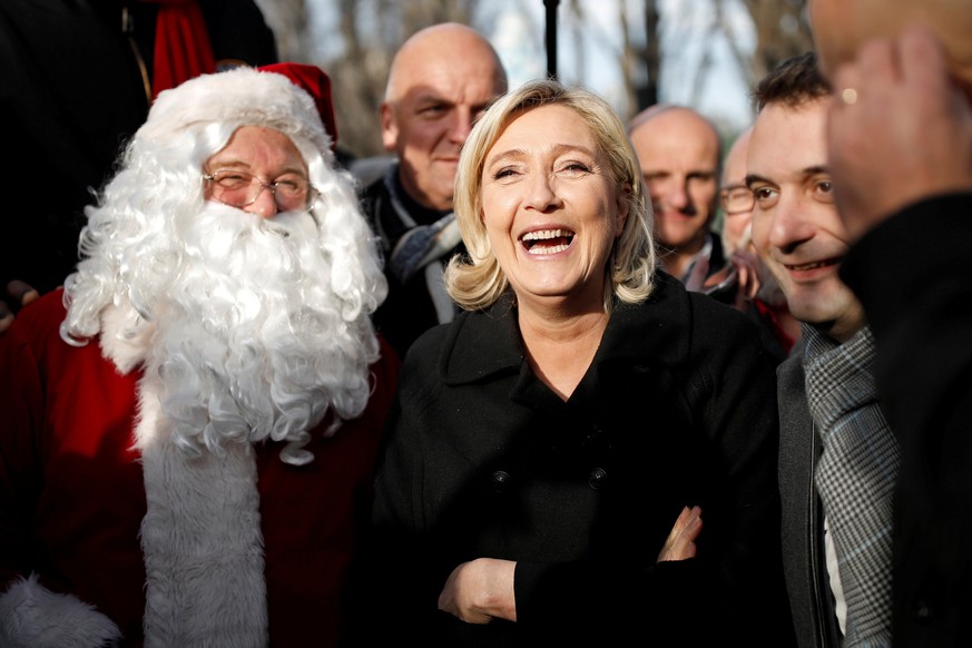 FILE PHOTO: French far-right Front National (FN) party president, member of European Parliament and candidate for French 2017 presidential election, Marine Le Pen (C) stands next to a man dressed as a ...
