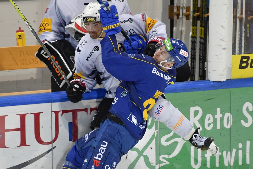 Zweikampf zwischen dem Fribourger Tristan Vauclair und dem Davoser Dario Meyer, beim Eishockey-Qualifikationsspiel der National League A zwischen dem HC Davos und dem HC Fribourg-Gotteron, am Freitag, ...