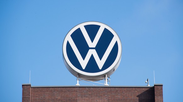 ARCHIV - 11.08.2021, Niedersachsen, Wolfsburg: Das VW-Logo auf fem Markenhochhaus von Volkswagen auf dem Gel