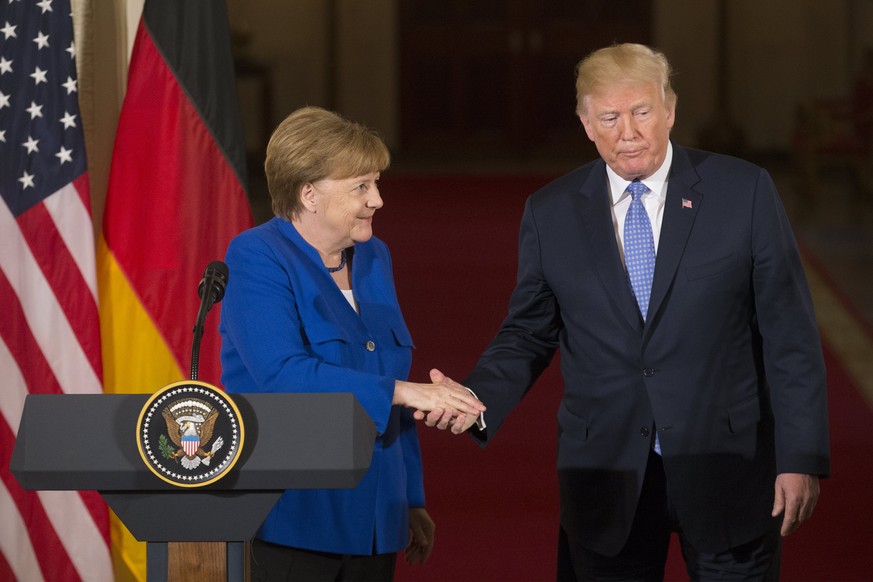 epa06697578 US President Donald J. Trump (R) and Chancellor of Germany Angela Merkel (L) shake hands while holding a joint news conference in the East Room of the White House in Washington, DC, USA, 2 ...