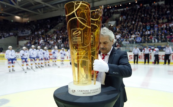 Ein Vertreter der Swiss National League stellt den Pokal auf einen Tisch vor dem zweiten Playoff Finalspiel der National League A zwischen den Kloten Flyers und den ZSC Lions, am Dienstag, 15. April 2 ...