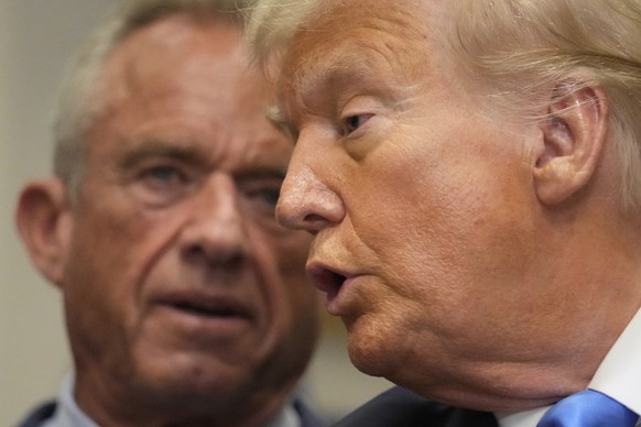 President Donald Trump speaks in the Roosevelt Room of the White House, Monday, Sept. 22, 2025, in Washington, as Health and Human Services Secretary Robert F. Kennedy Jr. listens. (AP Photo/Mark Schi ...