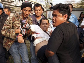 Ein Anhänger der thailändischen Regierung wird in Bangkok verletzt davon getragen.