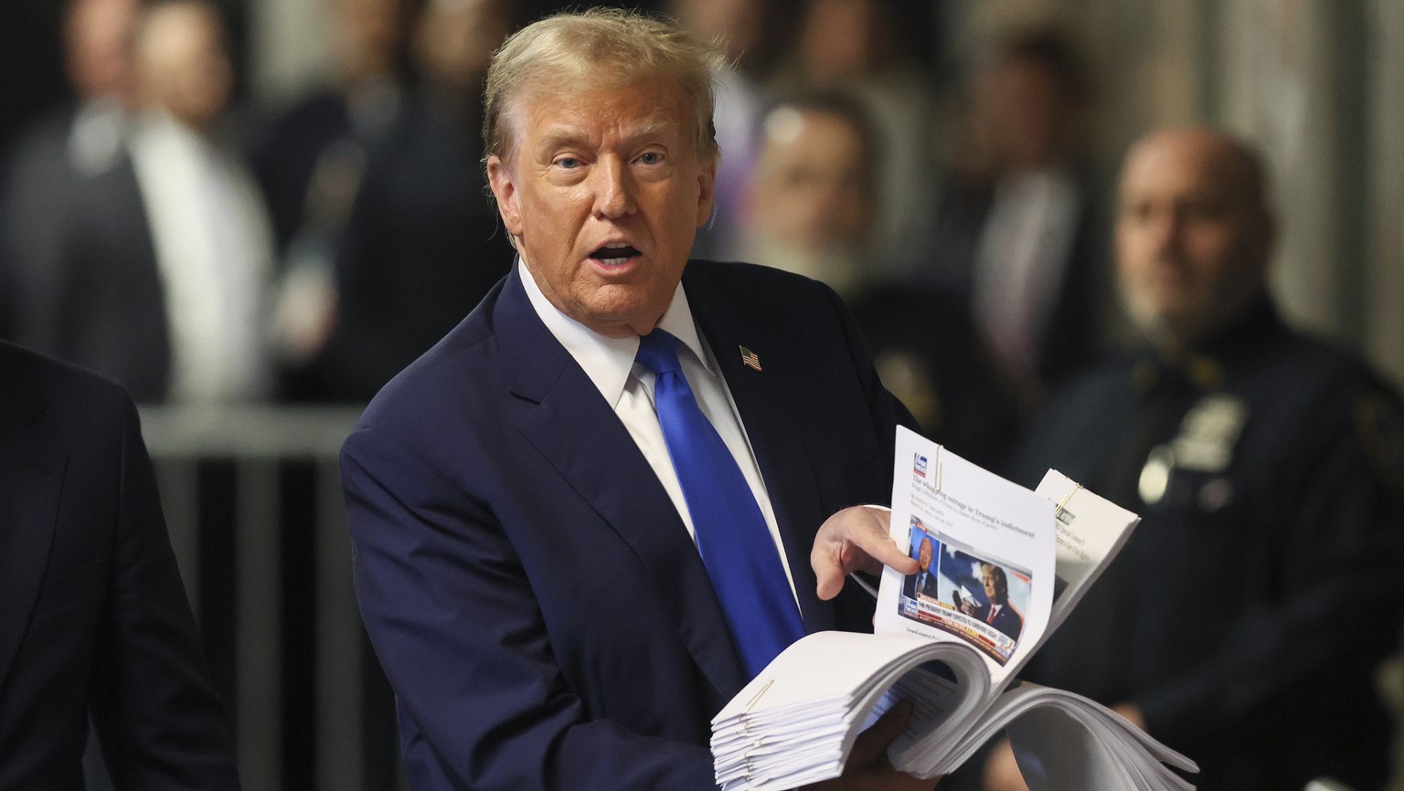 Former President Donald Trump speaks with the media while holding news clippings following his trial at Manhattan criminal court in New York on Thursday, April 18, 2024. (Brendan McDermid/Pool Photo v ...