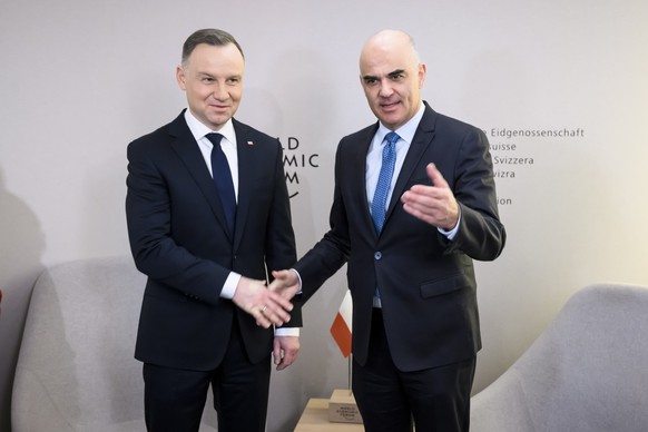 epa10412952 Andrzej Duda (L), President of Poland, shakes hands with Alain Berset (R), President of the Switzerland, during a bilateral meeting at the 53rd annual meeting of the World Economic Forum,  ...