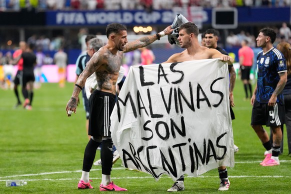 KEYPIX - Argentina's Giovani Lo Celso holds a banner with the words "The Malvinas are Argentine", referring to the Falkland Islands, while teammate Argentina's Nicolas Otamendi ges ...