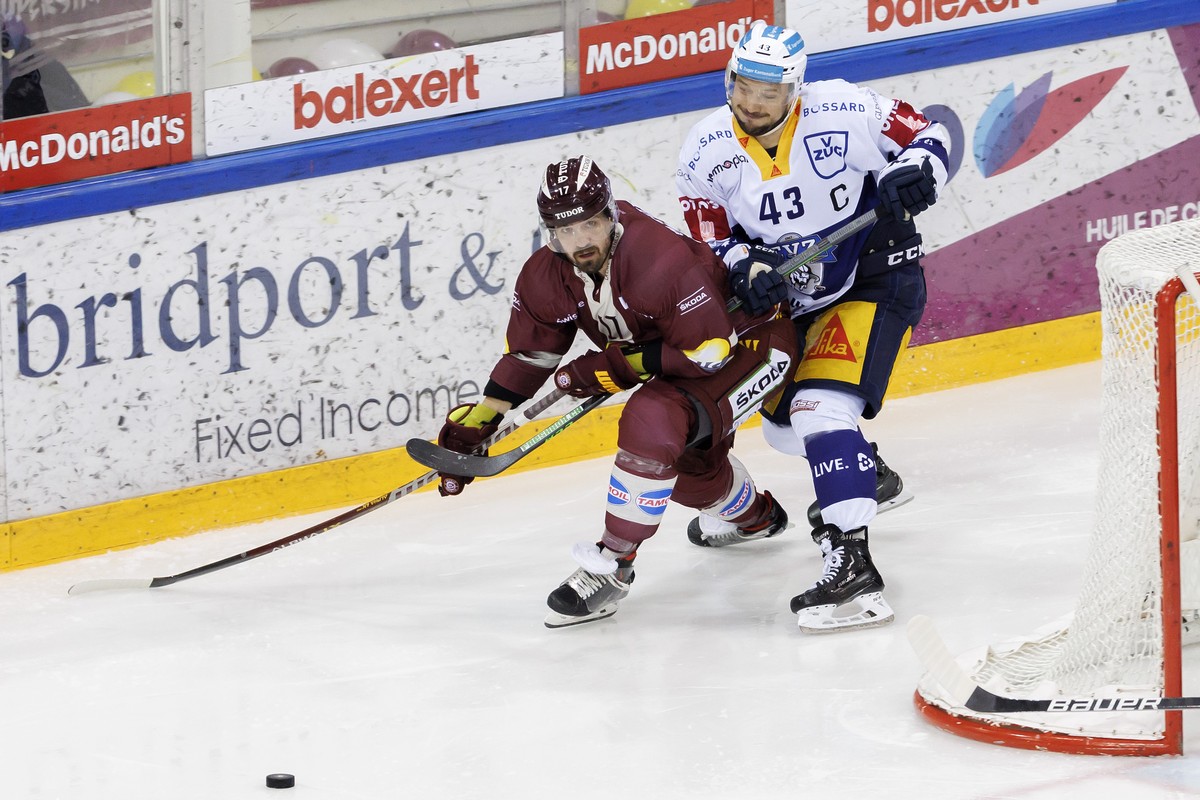 Geneve-Servette's defender Arnaud Jacquemet, left, vies for the puck with Zug's forward Jan Kovar, right, during the third leg of the National League Swiss Championship semifinal playoff gam ...