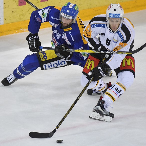 Der Tessiner Massimo Ronchetti, rechts, und der Bieler Philipp Wetzel, links, kaempfen um den Puck beim Eishockeyspiel der National League A zwischen dem EHC Biel und dem HC Lugano am Freitag, 18. Nov ...