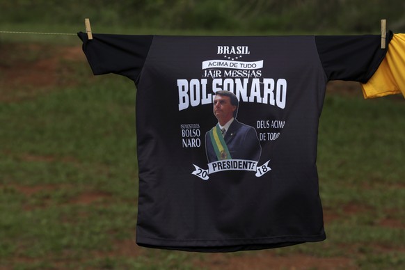 Three days before the second round of the election, supporters sell T-shirts showing presidential frontrunner Jair Bolsonaro wearing the presidential sash, in Brasilia, Brazil, Friday, Oct. 26, 2018.  ...
