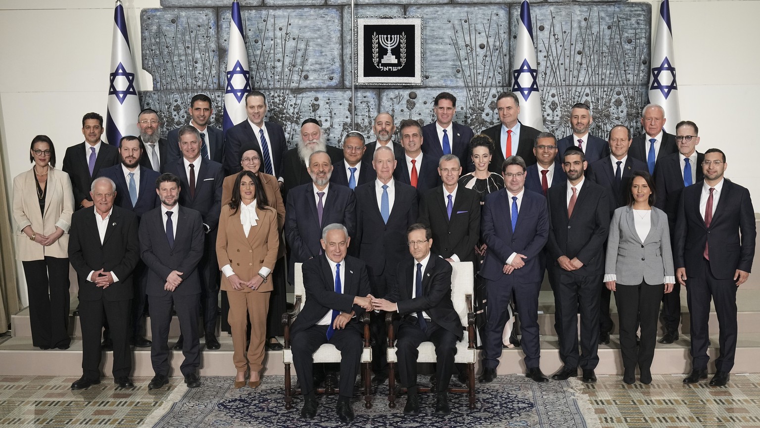 Israeli Prime Minister Benjamin Netanyahu, left, and President Yitzhak Herzog, seated, pose for a group photo with the ministers of Israel&#039;s 37th government at the President&#039;s residence in J ...
