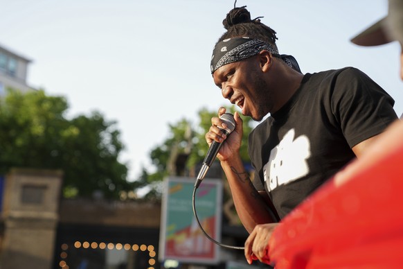 KSI addresses the crowd while promoting an energy drink, in an open-top bus traveling through London, Friday, June 17, 2022. (AP Photo/Scott Garfitt) KSI