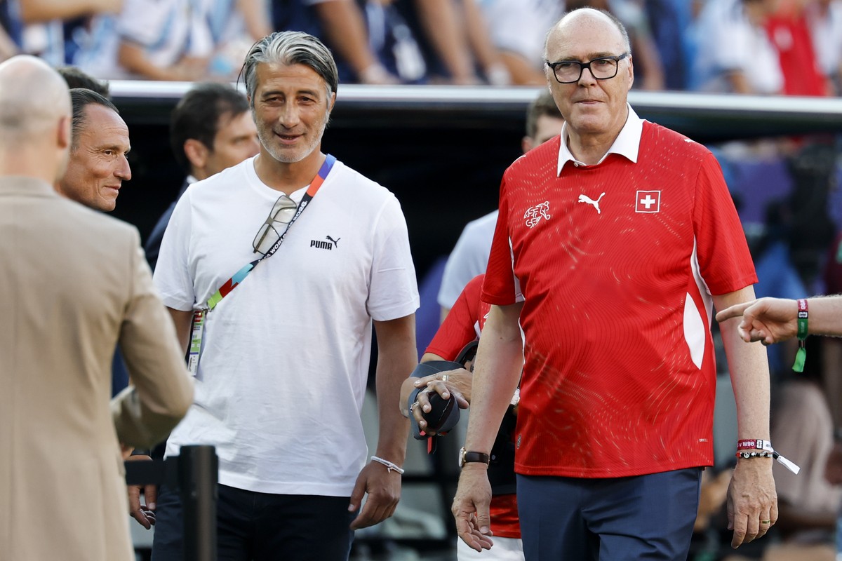 Switzerland's head coach Murat Yakin, left, speaks with Federal Councilor Martin Pfister, right, prior the World Cup quarter final match between Argentina and Switzerland at the Kansas City Stadi ...