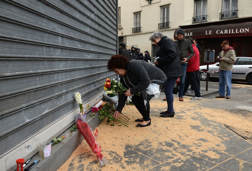 Trauernde legen Blumen beim Restaurant «Le Petit Cambodge» nieder. Hier flüchteten die Terroristen in einem Auto mit belgischen Kennzeichen. &nbsp;