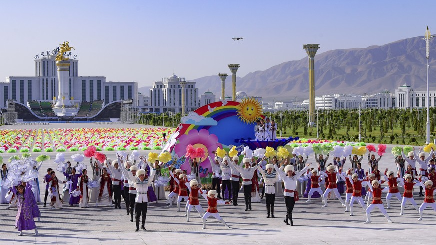 Actors wearing Turkmen national costumes dance during a ceremony of the officially opening of the new Arkadag city, about 30 kilometers (20 miles) south of the capital Ashgabat, Turkmenistan, Tuesday, ...