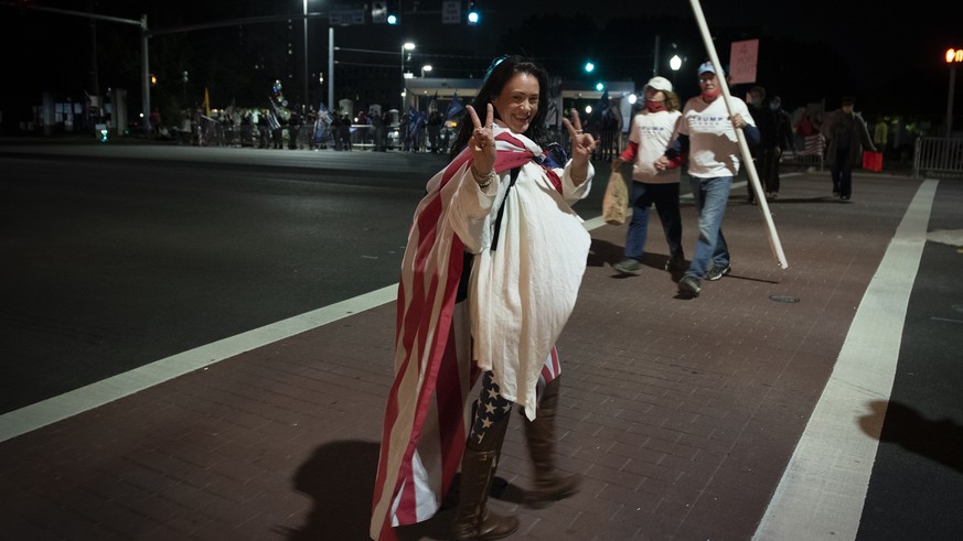 A supporter of President Donald Trump crosses the street near an entrance to Walter Reed National Military Medical Center in Bethesda, Md., Sunday, Oct. 4, 2020. Trump went to the hospital Friday afte ...