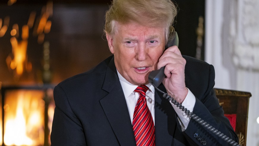 epa07247882 US President Donald J. Trump speaks with children who are calling the NORAD (North American Aerospace Defense Command) Santa tracker in the State Dining Room of the White House in Washingt ...