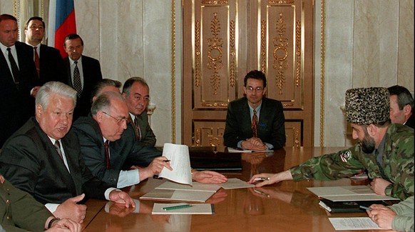 President Boris Yeltsin, left, speaks at his meeting with Chechnya&#039;s rebel leader Zelimkhan Yandarbiyev, right, in the Kremlin in Moscow Monday, May 27, 1996. Between them at the head of the tabl ...