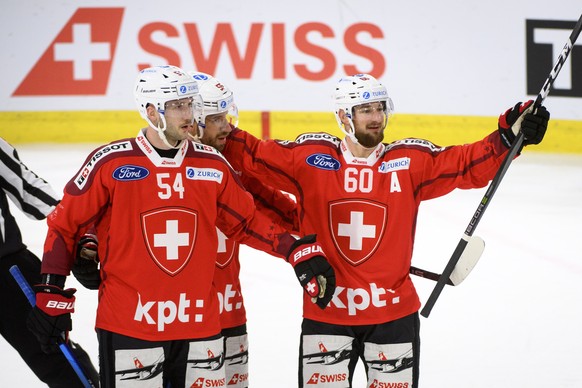 epa09645462 (LR) - Swiss defender Christian Marti, Swiss defender Romain Lovell and Swiss forward Tristan Cherui celebrate the second goal during an ice hockey match.