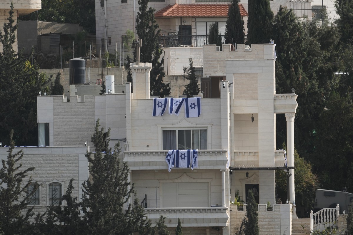 Israeli flags hang from a house belonging to Palestinian residents during an Israeli army operation in Hebron, in the occupied West Bank, Saturday, Oct. 24, 2026, a day after a Palestinian shooting at ...