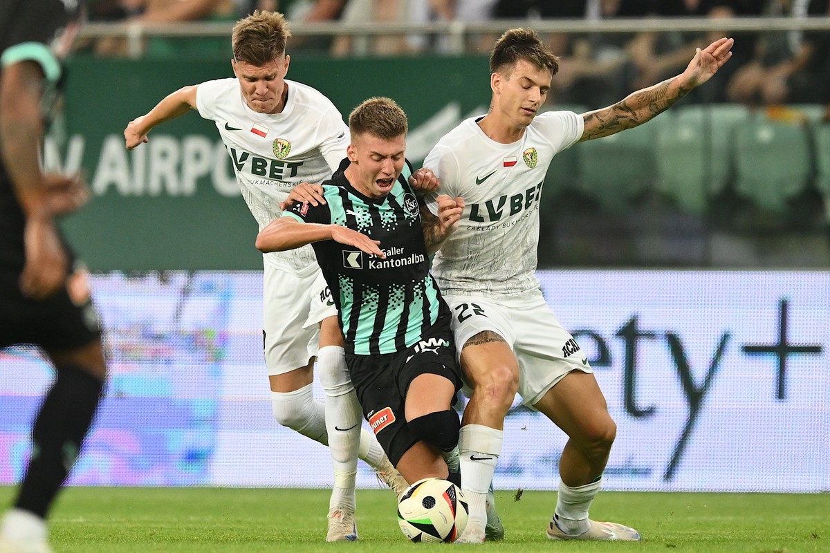 epa11550542 Piotr Samiec-Talar (L) and Mateusz Zukowski (R) of Slask Wroclaw in action against Christian Witzig (C) of FC St.Gallen during the UEFA Conference League third qualifying round second leg  ...