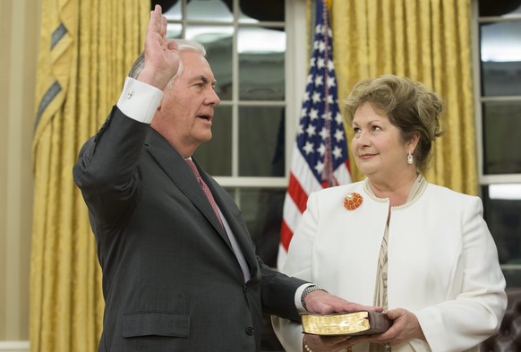 epa05765704 Rex Tillerson (L) is sworn-in as Secretary of State beside his wife Renda St. Clair (R), during a ceremony with US Vice President Mike Pence and US President Donald J. Trump in the Oval Of ...