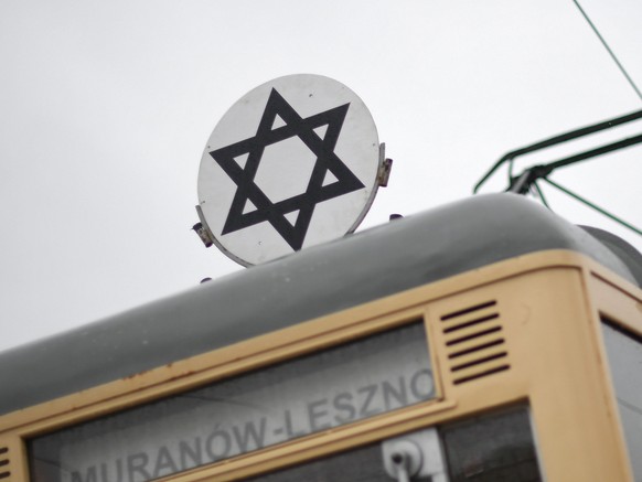 epa09713154 Historic tram marked with the Star of David on the streets of Warsaw, Poland, 27 January 2022. The empty vehicle symbolizes the tram running in the Warsaw Ghetto and is intended to remind  ...