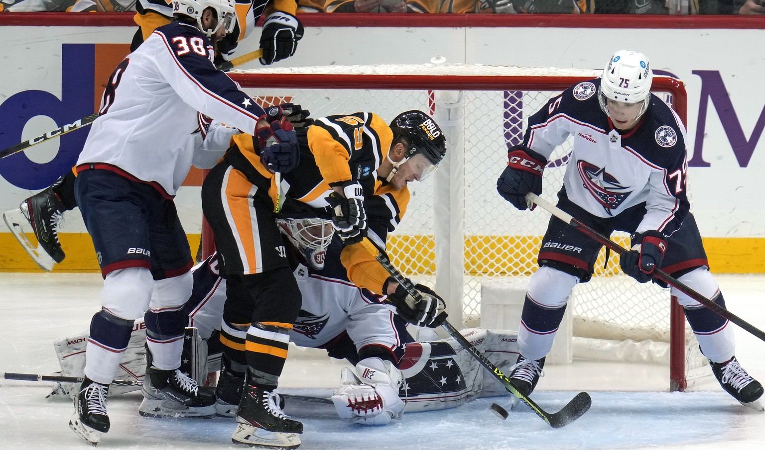 Pittsburgh Penguins&#039; Jake Guentzel, center, can&#039;t get his stick on a rebound in front of Columbus Blue Jackets goaltender Elvis Merzlikins, with Boone Jenner (38) and Tim Berni (75) defendin ...