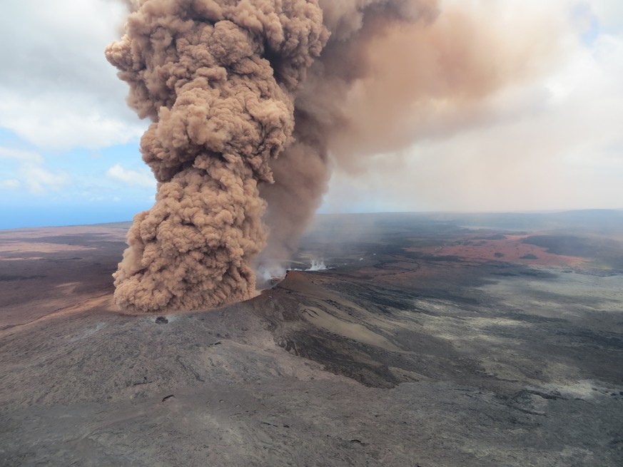 epa06712177 A handout photo made available by the United States Geological Survey shows a plume of ash rising from a crater in the Mount Kilauea volcano after a magnitude 6.9 earthquake struck the are ...