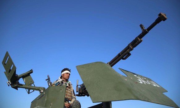 epa09195866 An Afghan security official stands guard as people celebrate the Eid al-Fitr, which marks the end of Ramadan, in Jalalabad, Afghanistan, 13 May 2021. The Taliban on 10 May, announced a thr ...