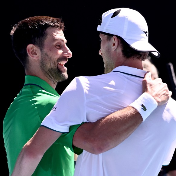 epa12669540 Novak Djokovic (L) of Serbia is congratulated on his win in the men's second round match by Francesco Maestrelli of Italy on day 5 of the 2026 Australian Open tennis tournament at Mel ...