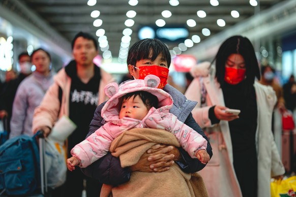 epaselect epa11874216 A traveler carrying a baby walks at the Shanghai Hongqiao Railway Station, in Shanghai, China, 04 February 2025. This year's Lunar New Year celebrations kicked off on 29 Jan ...