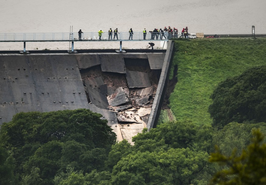 People human chain to lay sandbags on Toddbrook Reservoir near the village of Whaley Bridge, Cheshire, England, Thursday, Aug. 1, 2019. British police have ordered the evacuation of a town of 6,500 re ...