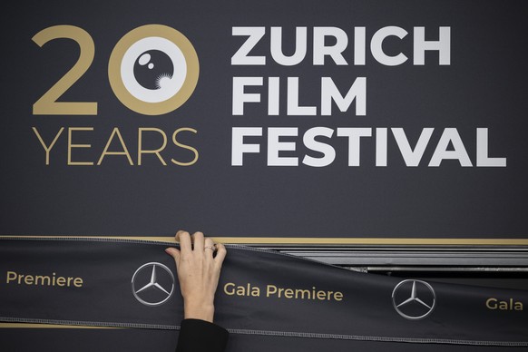 epa11649778 A woman replaces the advertising tape for the gala premiere at the 20th Zurich Film Festival (ZFF), in Zurich, Switzerland, 08 October 2024. The 20th ZFF runs from 03 to 13 October 2024.�  ...