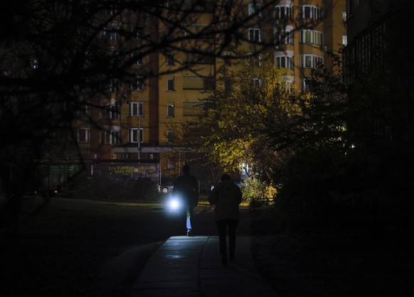 epa12516807 People walk with flashlights on a dark street during an electricity cut-off in Kyiv, Ukraine, Ukraine, 10 November 2025, amid the ongoing Russian invasion. The main target of the Russian s ...