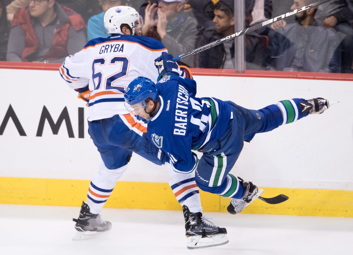 Edmonton Oilers' Eric Gryba, left, checks Vancouver Canucks' Sven Baertschi during the third period of an NHL hockey game Friday, Oct. 28, 2016, in Vancouver, British Columbia. (Darryl Dyck/ ...
