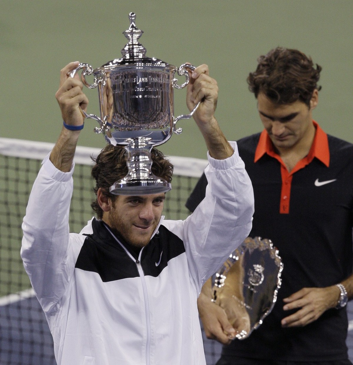 Juan Martin del Potro, of Argentina, holds up the championship trophy after winning the men's finals championship over Roger Federer, right, of Switzerland, at the U.S. Open tennis tournament in  ...
