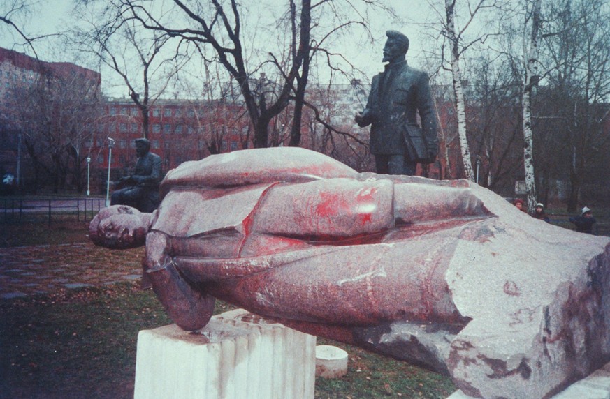 November 1991 -- Moscow: Graffiti-defaced statue of Joseph Stalin lying forlornly on its side, framed by one of Yakov Sverdlov, among Communist heroes monuments dismantled and discarded in park area a ...