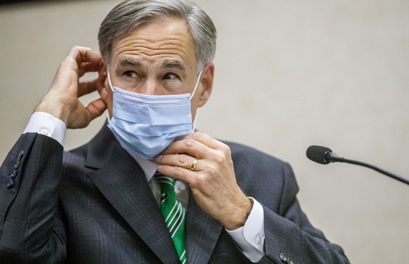 FILE - In this June 16, 2020, file photo, Texas Gov. Greg Abbott adjusts his mask after speaking in Austin, Texas. Abbott on Thursday, July 2, ordered that face coverings must be worn in public across ...