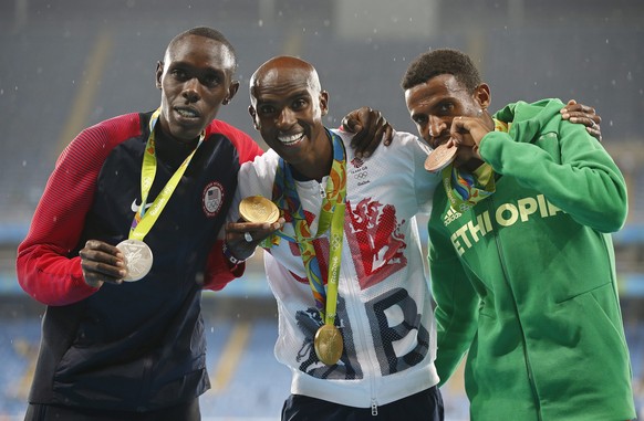 epa05504276 Mo Farah (C) of Britain poses with his gold medal on the podium after winning the men&#039;s 5000m final of the Rio 2016 Olympic Games Athletics, Track and Field events at the Olympic Stad ...