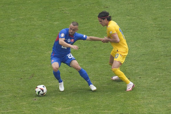 Slovakia&#039;s Stanislav Lobotka, left, and Romania&#039;s Ianis Hagibattle for the ball during a Group E match at the Euro 2024 soccer tournament in Frankfurt, Germany, Wednesday, June 26, 2024. (AP ...