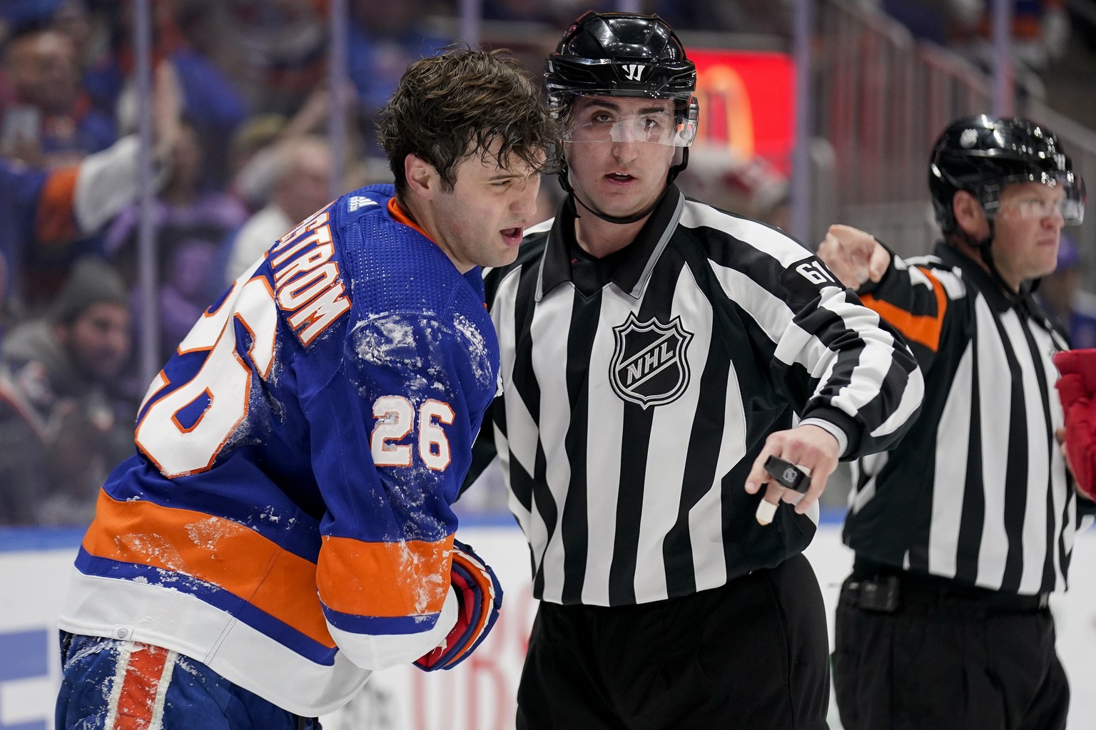 New York Islanders right wing Oliver Wahlstrom (26) is helped to his feet after colliding with Detroit Red Wings goaltender Alex Nedeljkovic in the second period of an NHL hockey game, Thursday, March ...