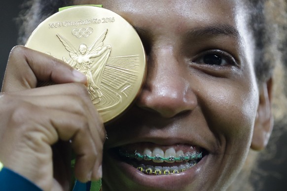 Brazil's Rafaela Silva celebrates after receiving the gold medal of the women's 57-kg judo competition at the 2016 Summer Olympics in Rio de Janeiro, Brazil, Monday, Aug. 8, 2016. (AP Photo/Markus Schreiber)