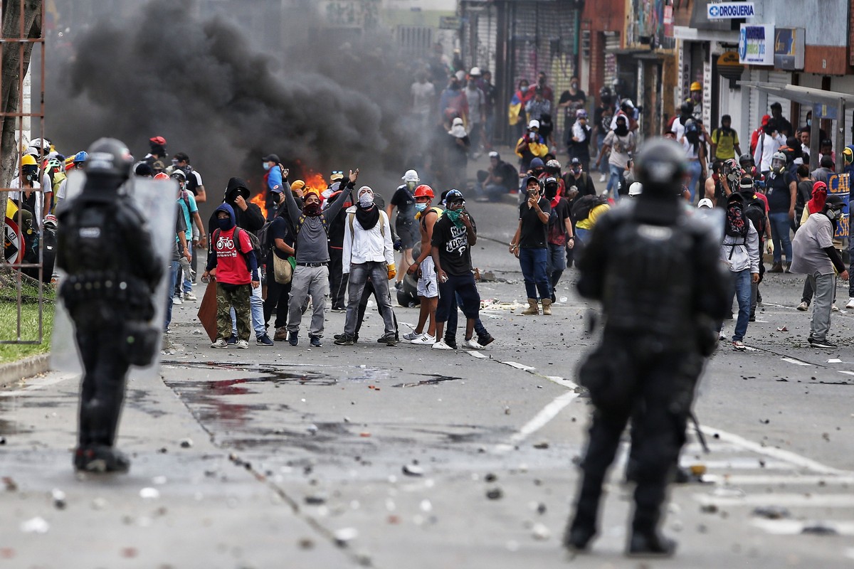 epa09355752 Demonstrators clash with members of the Mobile Anti-Riot Squad (ESMAD) of the Colombian Police at the Loma de la Cruz sector in Cali, Colombia, 20 July 2021. At least 22 people were arrest ...
