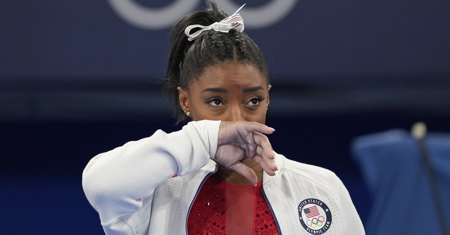 Simone Biles, of the United States, watches gymnasts perform after she exited the team final with apparent injury, at the 2020 Summer Olympics, Tuesday, July 27, 2021, in Tokyo. The 24-year-old reigni ...