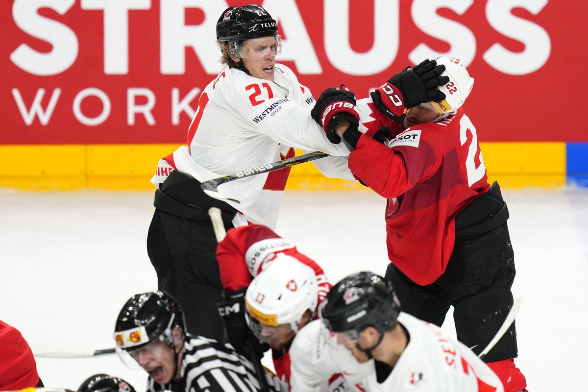Canada's Kaiden Guhle, left, fights with Switzerland's Nino Niederreiter during the preliminary round match between Canada and Switzerland at the Ice Hockey World Championships in Prague, Cz ...