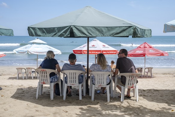 epa10605656 Foreign tourists sitting on a beach in Kuta, Bali, Indonesia, 03 May 2023. According to data published on 02 May 2023 by the Indonesian Central Statistics Agency (BPS), the number of forei ...