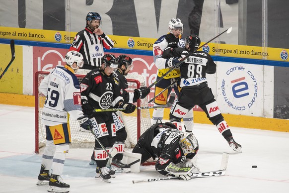 Lugano&#039;s player Santeri Alatalo, Lugano&#039;s goalkeeper Niklas Schlegel, Zug&#039;s player Fabrice Herzog and Lugano&#039;s player Mikkel Boedker, from left, fight for the puck during the preli ...