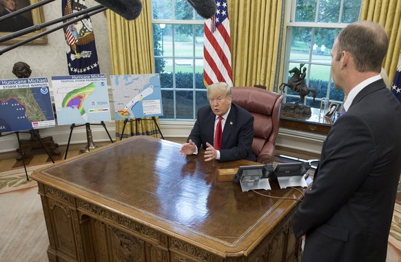 epa07084030 US President Donald J. Trump (C) delivers remarks to members of the news media on Hurricane Michael, beside maps of the projected path of the hurricane; while meeting with US Secretary of  ...